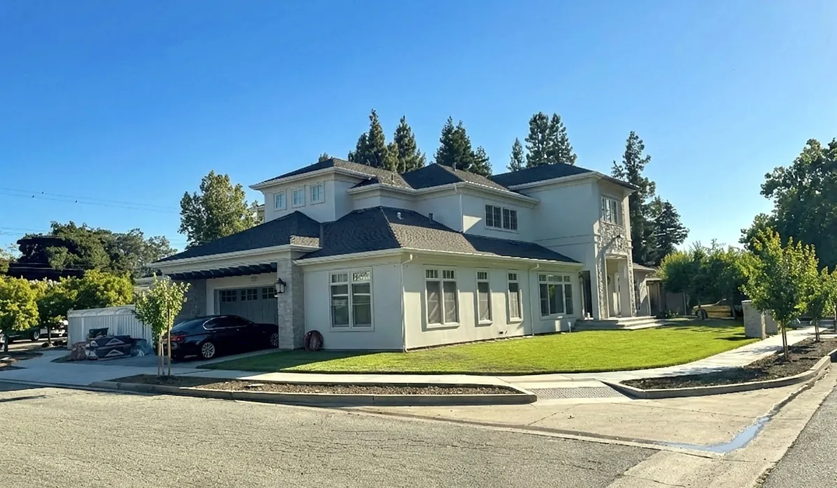 Two-story white traditional home with a gray roof and front lawn