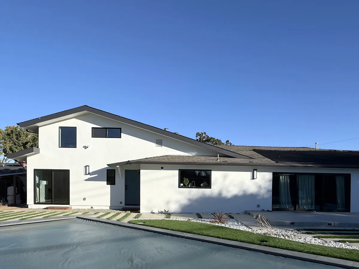 Back of the remodeled home and two-story ADU, white stucco with black windows and new landscaping