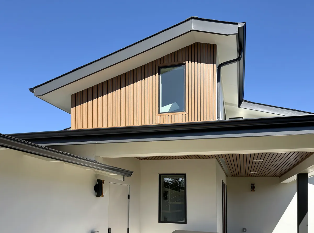 Front of the two-story ADU with wood-slat siding, black trim and a matching slatted soffit