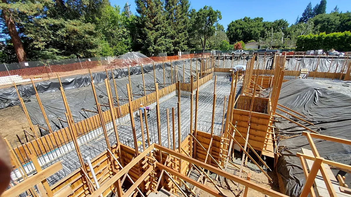 New home under construction: foundation formwork and rebar across a large excavated site